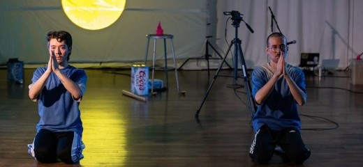 evan ray suzuki and Glenn Potter-Takata kneeling with their hands together in gassho with a projection of the moon in the background.