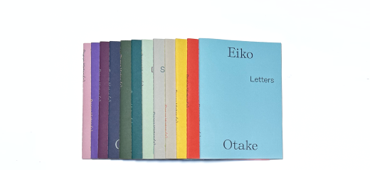 Laid in an overlapping line on a white surface are 12 booklets each in a different bright color. The one farthest to the right and in light blue reads in black text Eiko across the top and Otake across the bottom with the word Letters placed above and to the right of center.