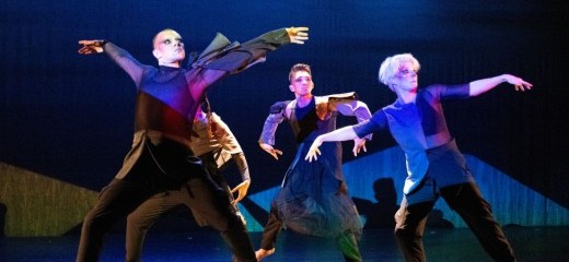 The four dancers of soapbox, each with dark Gothic eye and red facial makeup in tight black pants and tops of geometric blocks of dark blue and black colors stand in a spotlight surrounded by lighting in black, blues and some red hues. Tyler Rivera and Megan Mazarick stare either fearfully or menacingly to the far right in wide stances and extended arms. Behind them, Alonzo Magsino, and, partially hidden, Danielle Currica stare intently in the same direction but with arms folded inward.
