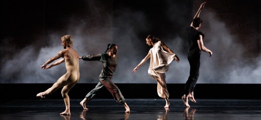 (Left to Right): Spencer Weidie, Jennifer Payan, Ashley Merker, Patrick Needham. Four young dancers are captured in multiple states of joyous abandon. One faces away from us in a tan body-suit that clings to his flesh, his arms and one leg pointing to the corner, while another wearing dark burgundy lunges forward on one leg with her arms extended behind her. A third dancer, wearing white, points to the floor as she tips her long spine to the side; while the fourth, wearing black and with his back to us, has just leapt from the floor, his left arm gently reaching above him.