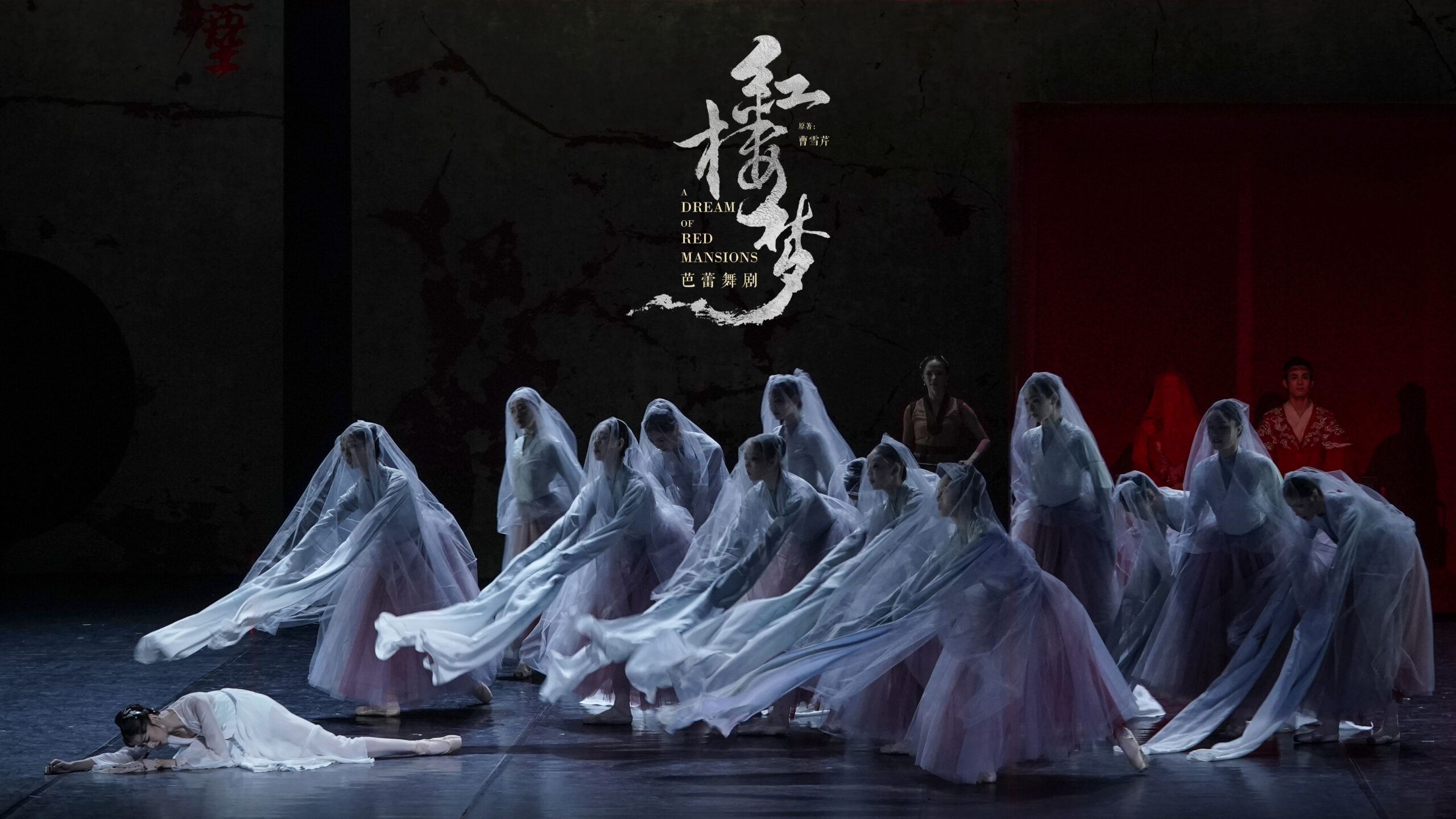 This is a haunting stage moment. Downstage left, Lin Daiyu lies collapsed on the floor, her pale costume blending into the cool blue-gray lighting, evoking fragility and lifelessness. Surrounding her, a semicircle of female dancers in white veils and soft pink skirts lean forward in unison, their long, flowing sleeves extended toward her like drifting currents or mourning spirits. The translucent veils soften their faces, creating an ethereal, ghostlike presence reminiscent of the Wilis from Giselle. The overall composition—low, reaching arms, rippling fabric, and a grounded central figure—creates a visual image of collective grief, where movement, costume, and spatial design merge into a poetic expression of mourning.