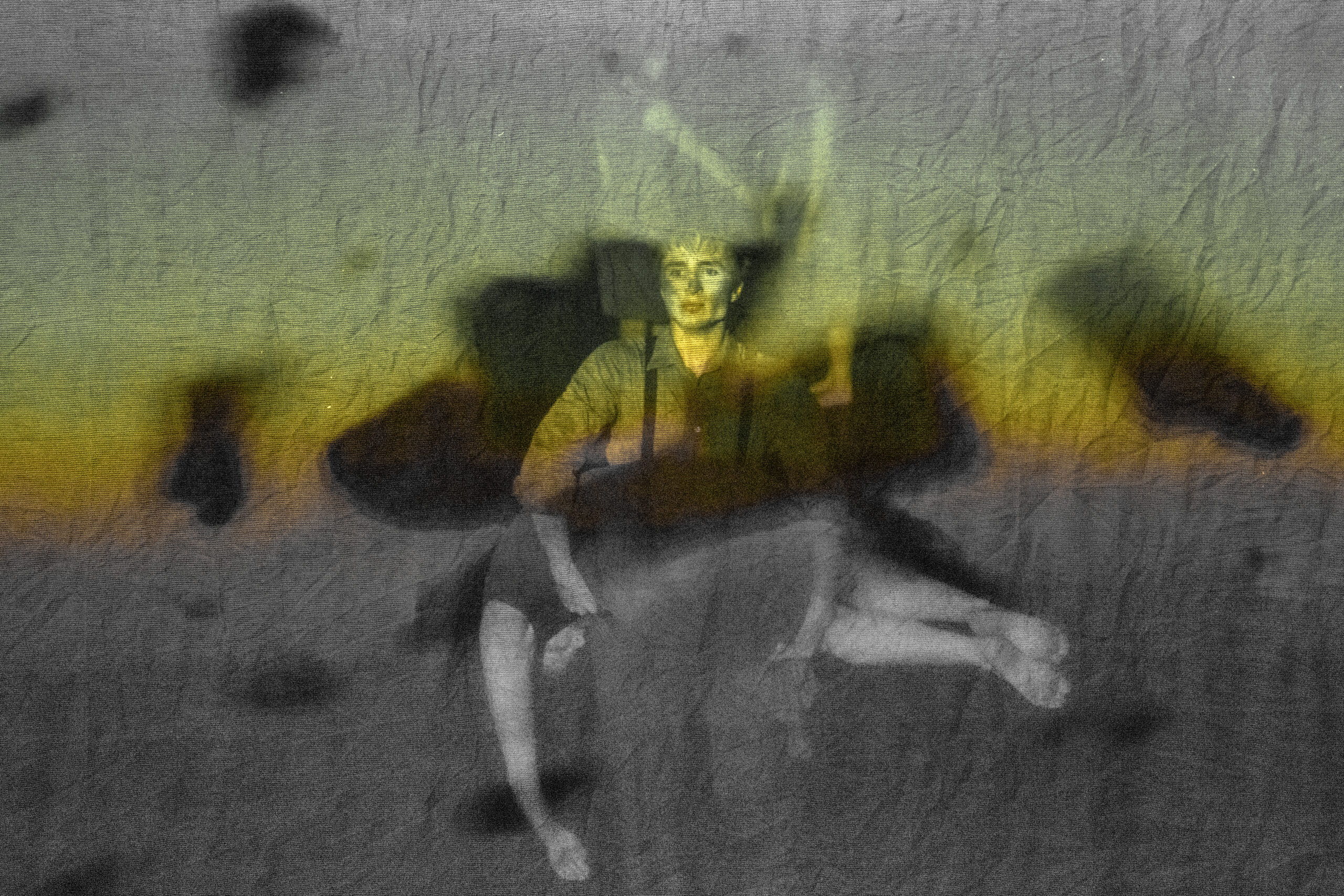 A projection screen shows big black chunks of falling debris. Behind that, we see a person with dirt on their cheeks and wearing dark overalls, carrying another person in feont of them across their stomach. The person being carried wears a gray dress, and their bare limbs hang lifeless. Beyond these two, in the distance, we can faintly see another pair, facing one another with their hands extended towards one another.