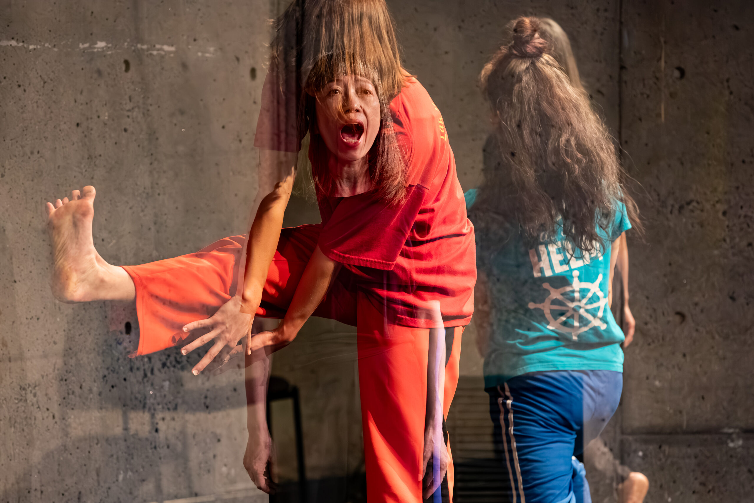 A photo from Nami Yamamoto’s work of an Asian femme with blunt bangs and a shoulder-length haircut, standing open-mouthed. This image is translucently superimposed onto another image of two dancers wearing colorful tshirts and sweats, engaging in physical scores.